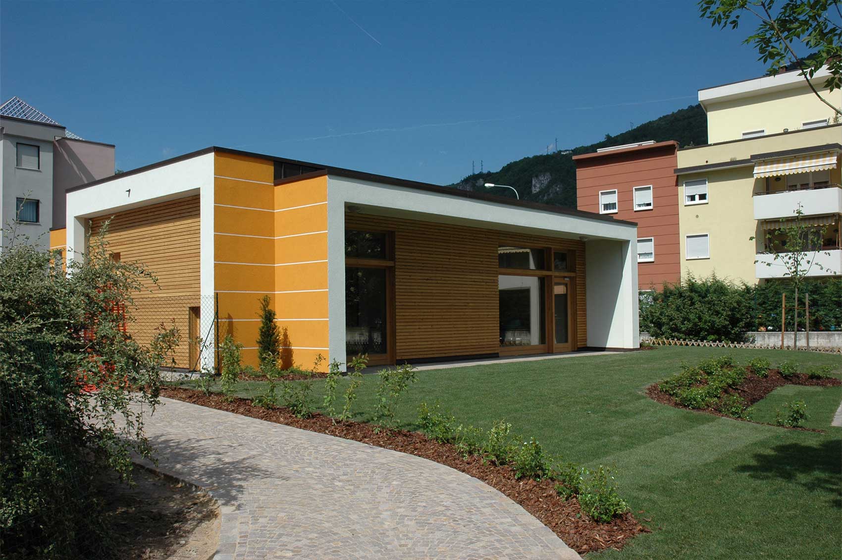 Außenansicht von Haus Gardasee mit orangefarbener Fassade und überdachtem Eingang
