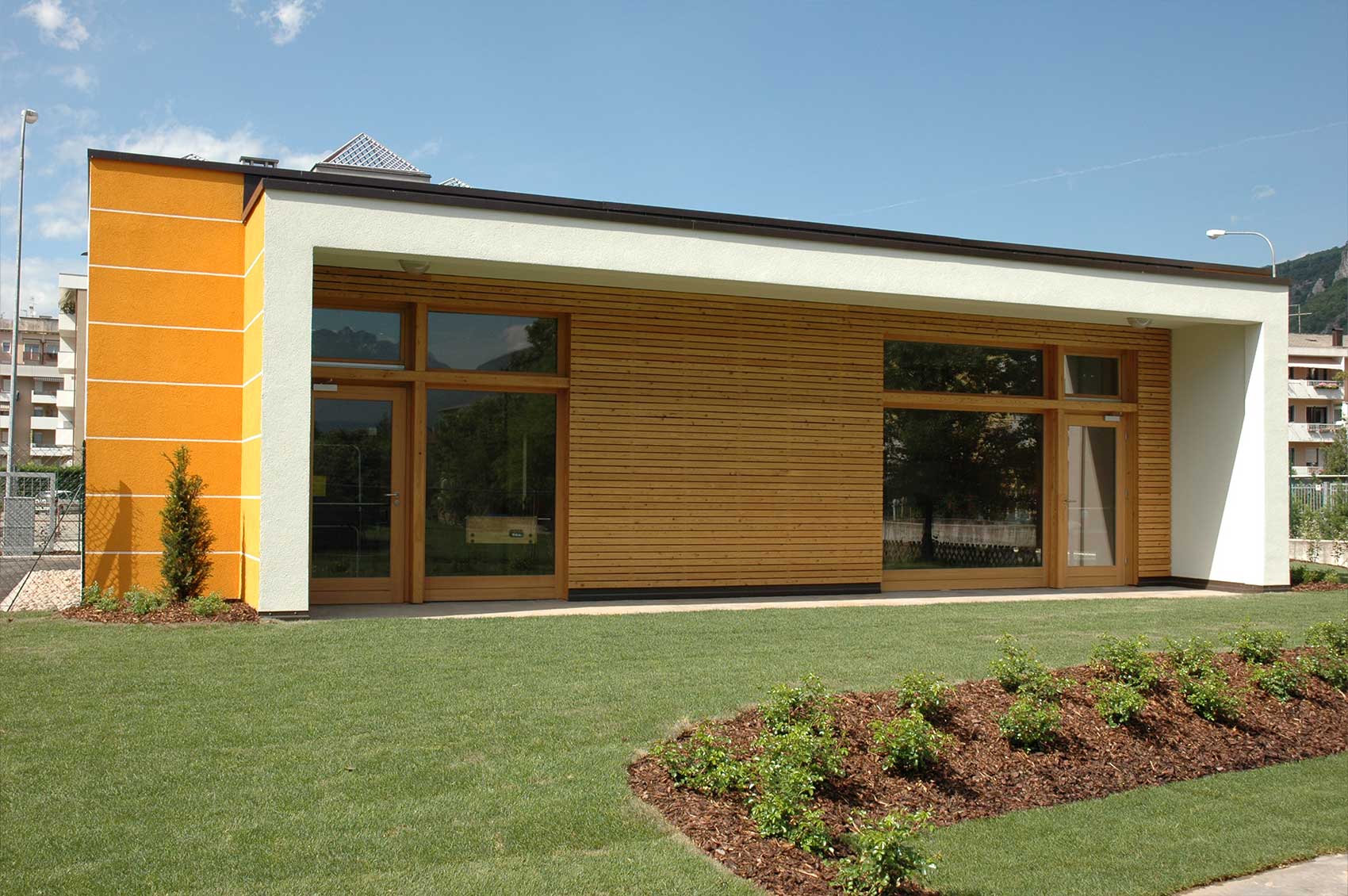 Haus Gardasee · Gartenseite Gartenseite des Holzhauses Gardasee mit großen Fenstern und Holzverschalung