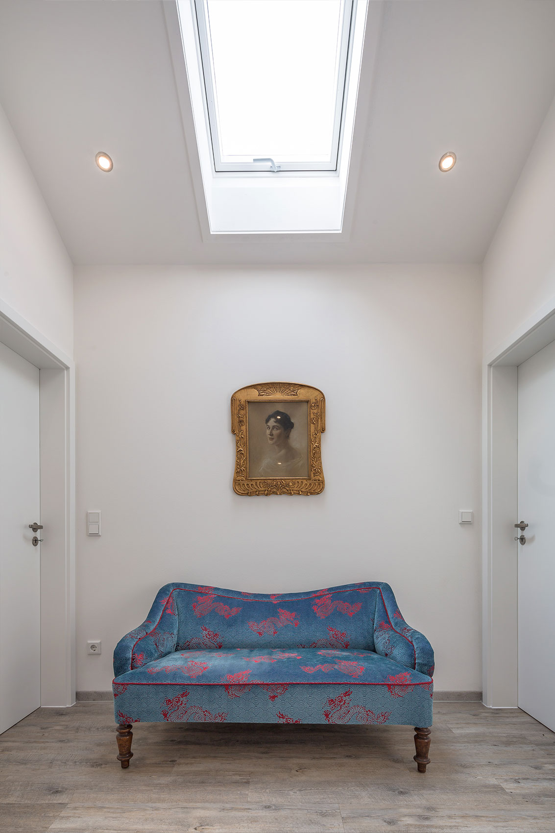 Heller Flur mit Dachfenster und Bild an der Wand