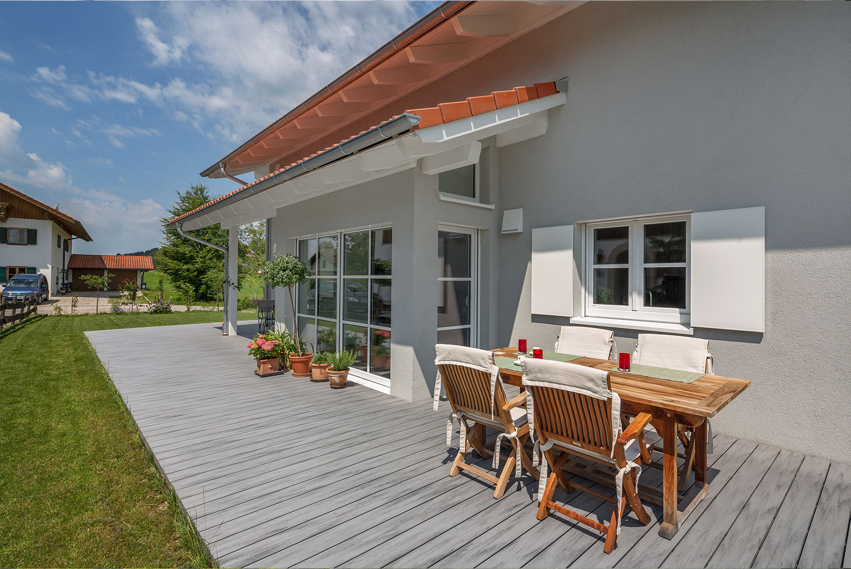 Terrasse von Haus Ulmensee mit großem Esstisch und Markise