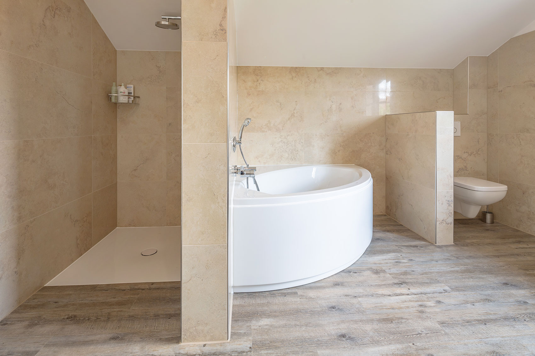 Badezimmer mit weißer Badewanne und beigefarbenen Fliesen
