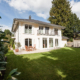 Gartenansicht der Villa Victoria mit Rasenfläche und sonniger Terrasse
