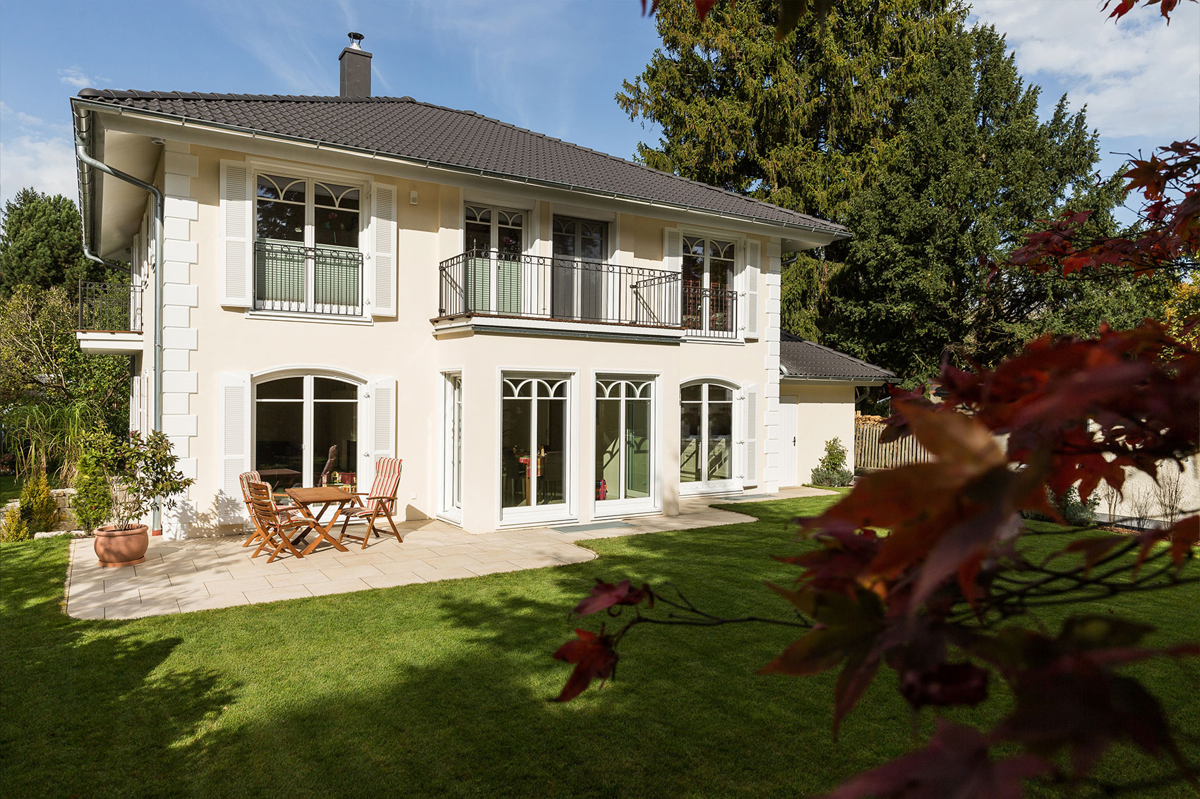 Villa Victoria als Holzhaus mit heller Fassade und Terrasse zum Garten