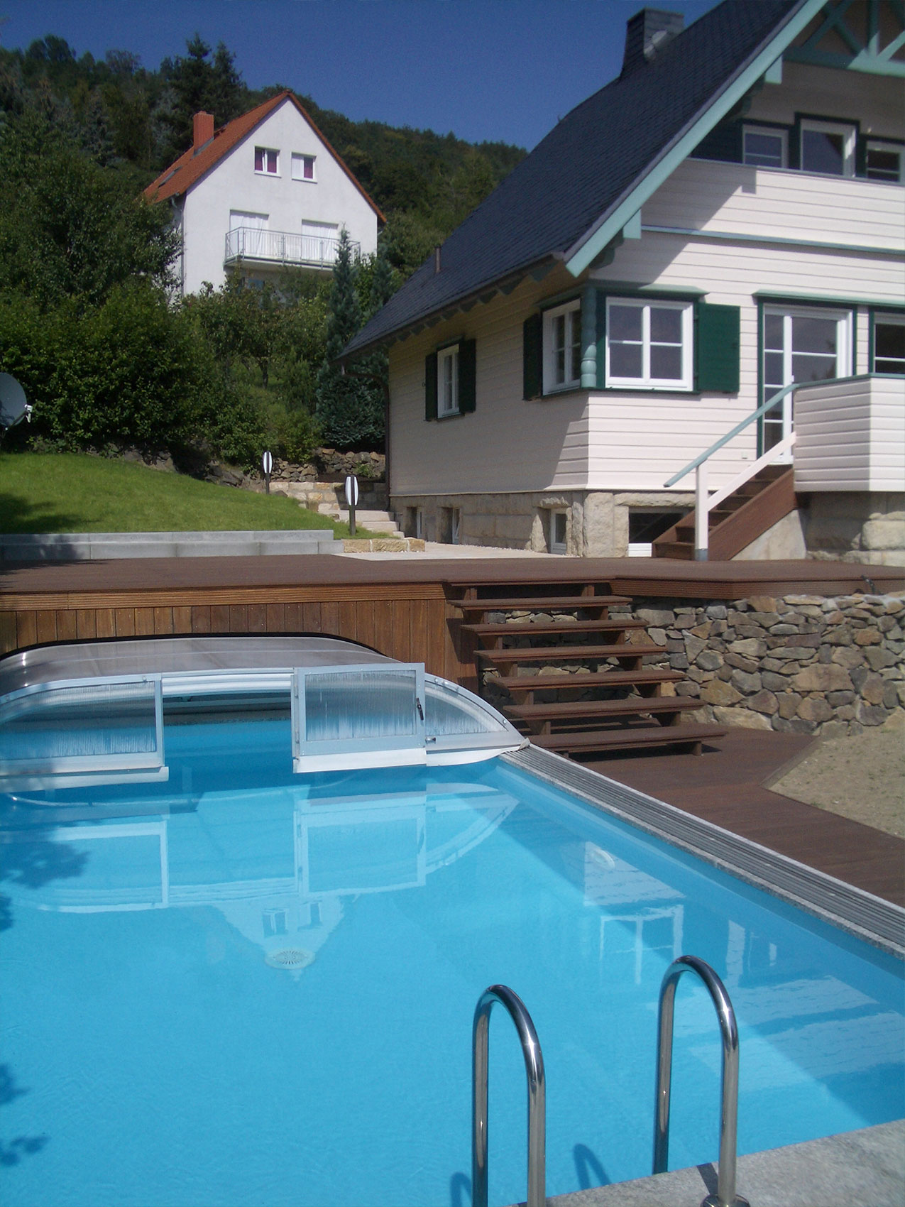 Holzhaus mit Terrasse und Pool im Garten