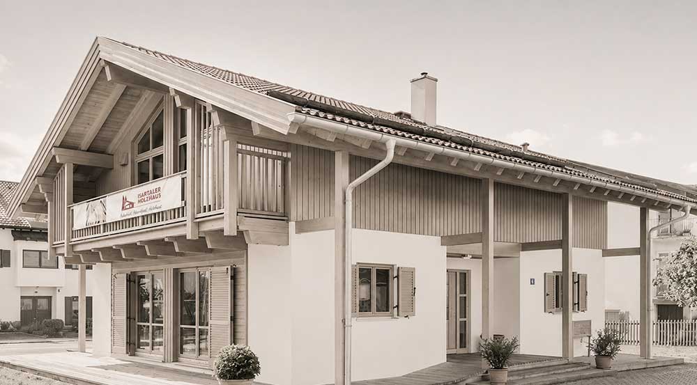 Holzhaus Holzkirchen · Außenansicht Außenansicht eines Holzhauses mit Balkon und Holzverkleidung am Obergeschoss