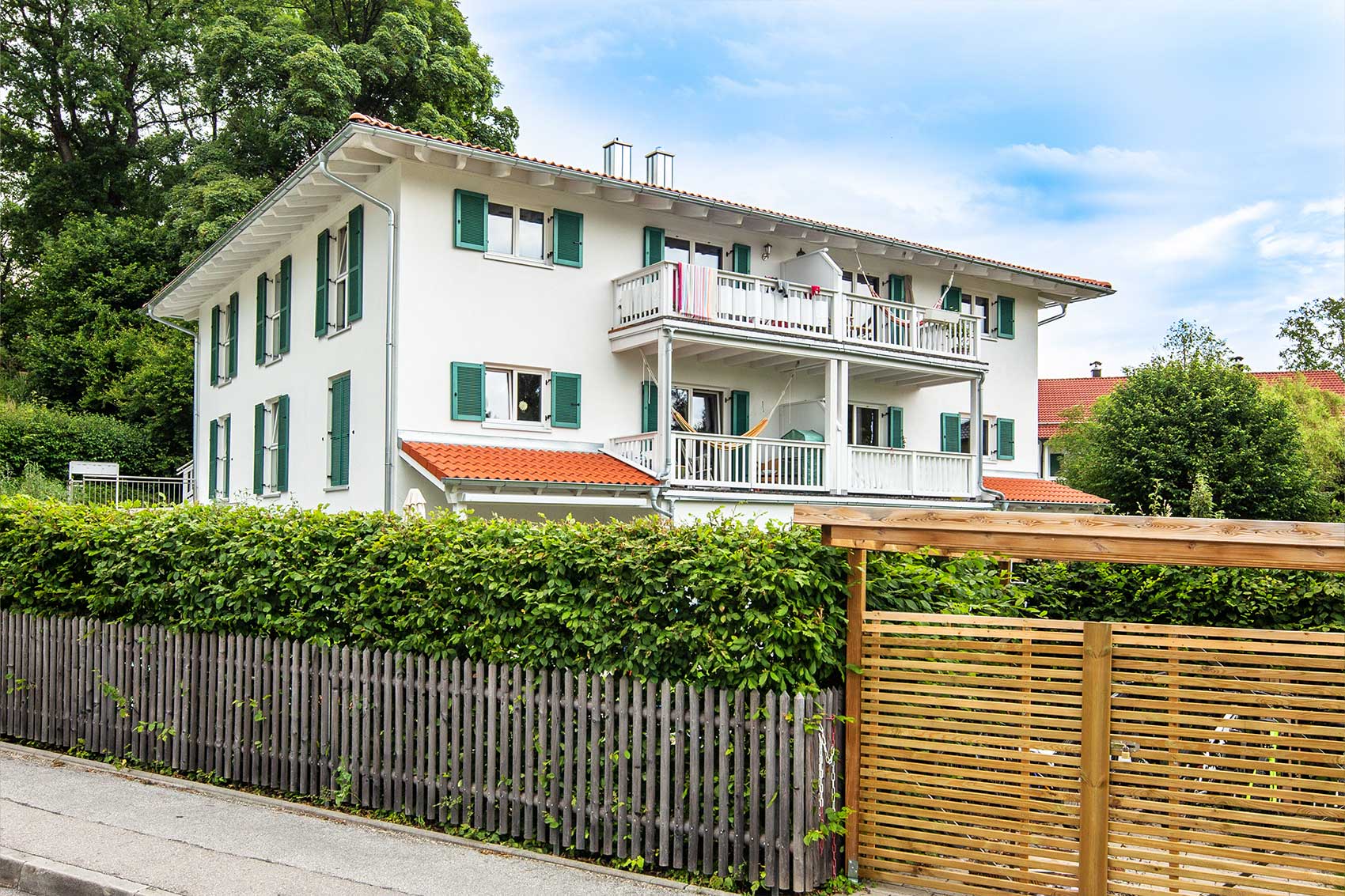 Mehrfamilienhaus Klostersee in Holzbauweise mit Balkonen und grünen Fensterläden