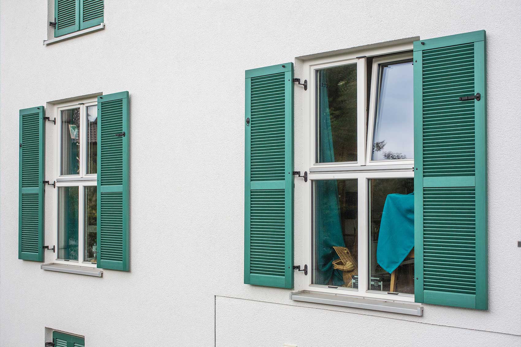 Fenster mit grünen Fensterläden im Mehrfamilienhaus Klostersee