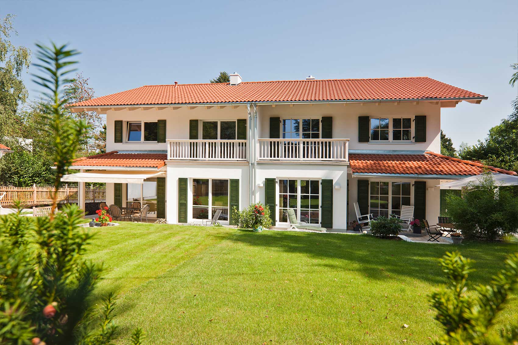 Gartenfassade von Haus Waldsee mit zwei Balkonen und großen Fensterflächen