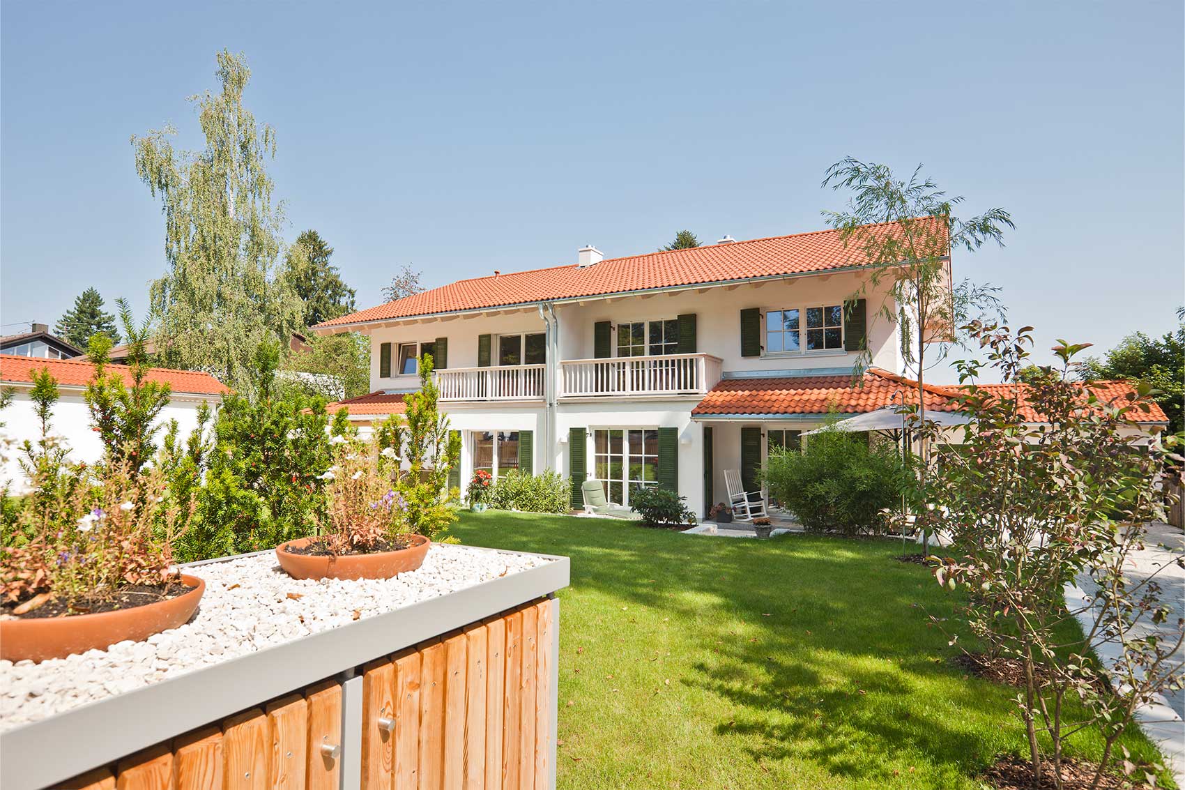 Doppelhaus Waldsee in Holzbauweise mit Balkonen und Terrassen, vom Garten aus gesehen