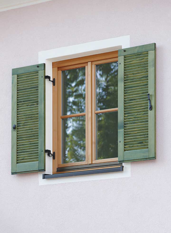 Holzfenster mit grünen Klappläden am Doppelhaus Wörthersee