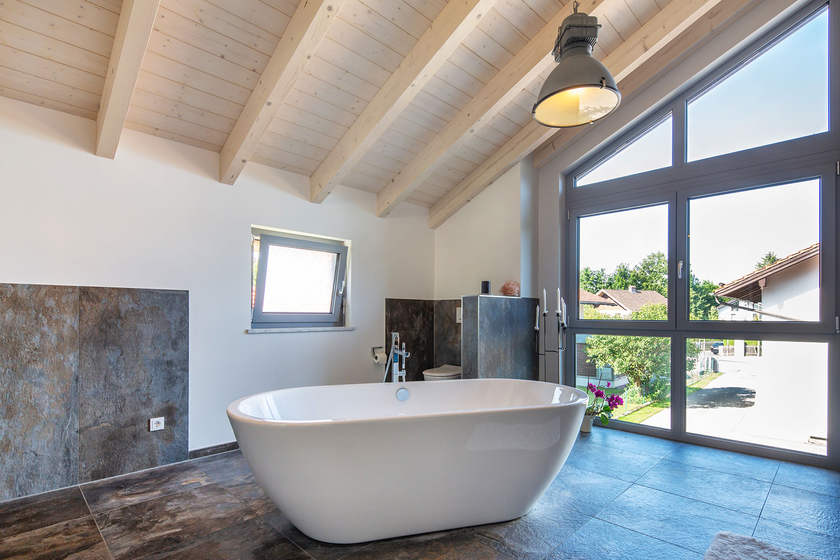 Bad mit freistehender Badewanne und sichtbarer Holzdecke in Haus Leitensee