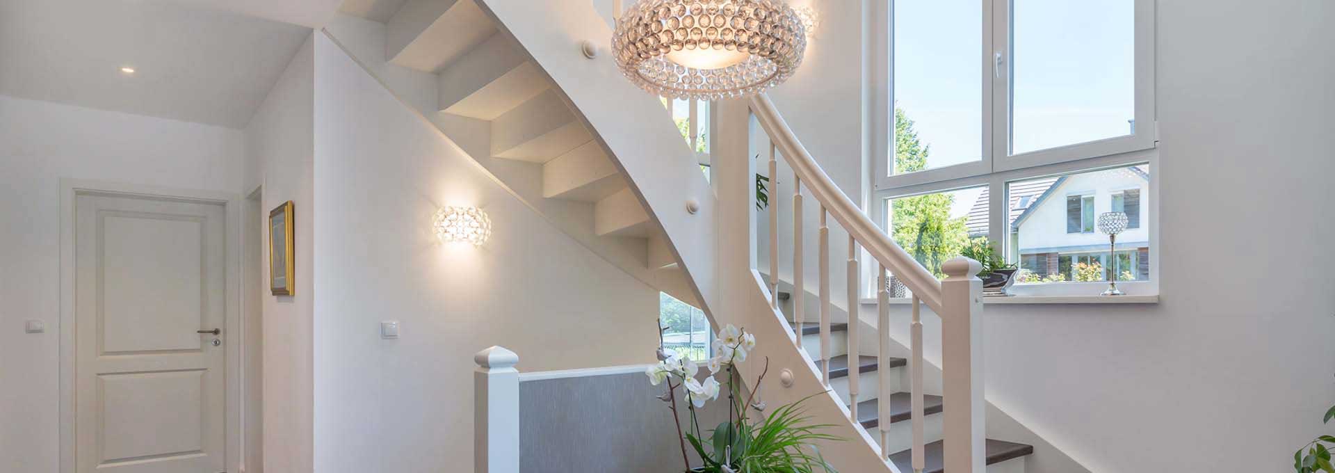 Treppenhaus · Heller Eingangsbereich Weiße Treppe und runde Hängelampe in einem hellen Eingangsbereich