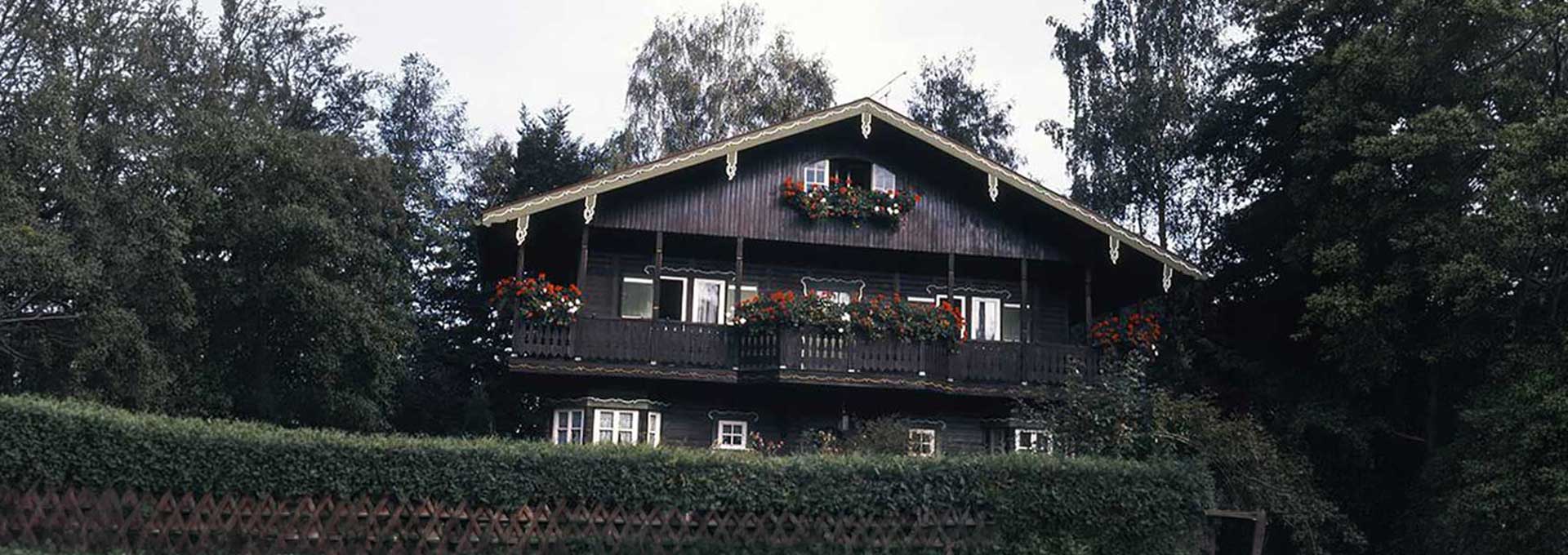Holzhaus · Traditionelle Fassade Historisches Holzhaus mit Satteldach und blumengeschmückten Balkonen