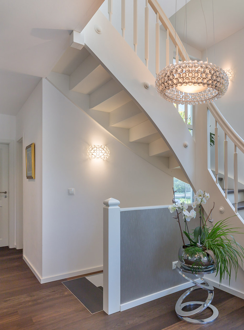 Eingangsbereich · Treppe Heller Eingangsbereich mit weißer Treppe und dekorativer Hängelampe